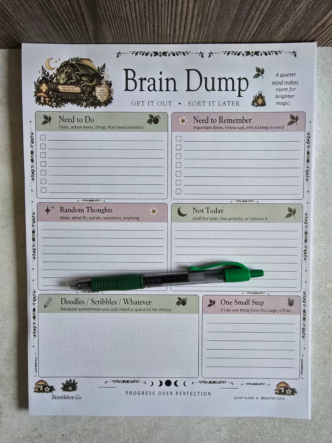 Full-size Brain Dump organizer notepad shown with a green pen for scale
