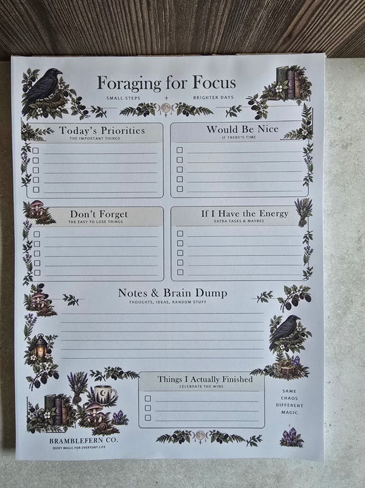 Front view of Foraging for Focus woodland daily planner notepad featuring ravens, mushrooms, priority checklists and notes