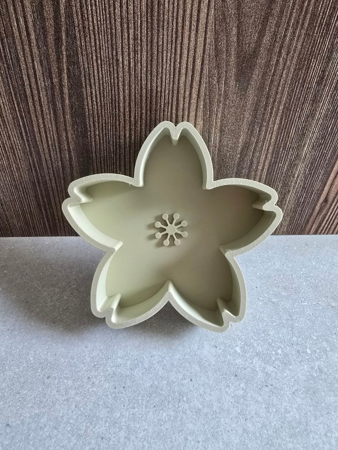 Khaki cherry blossom jewelry dish showing its five-petal shape.