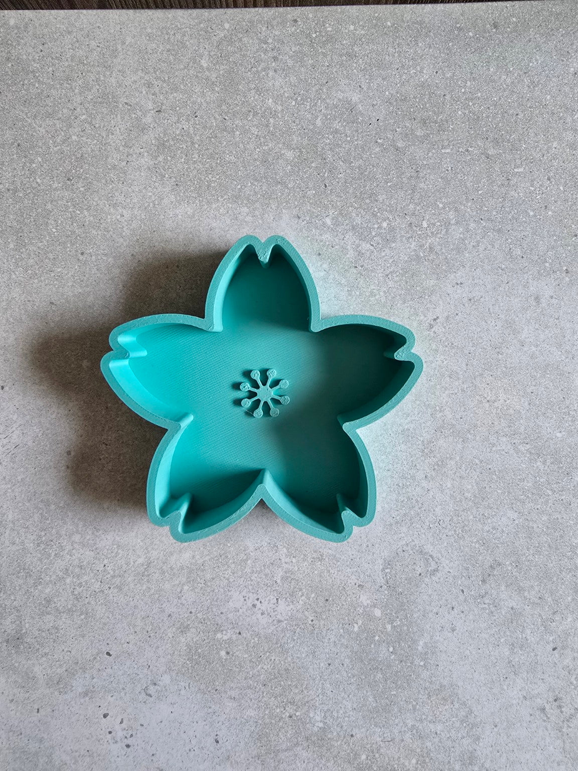 Teal five-petal 3D printed cherry blossom trinket dish, empty.