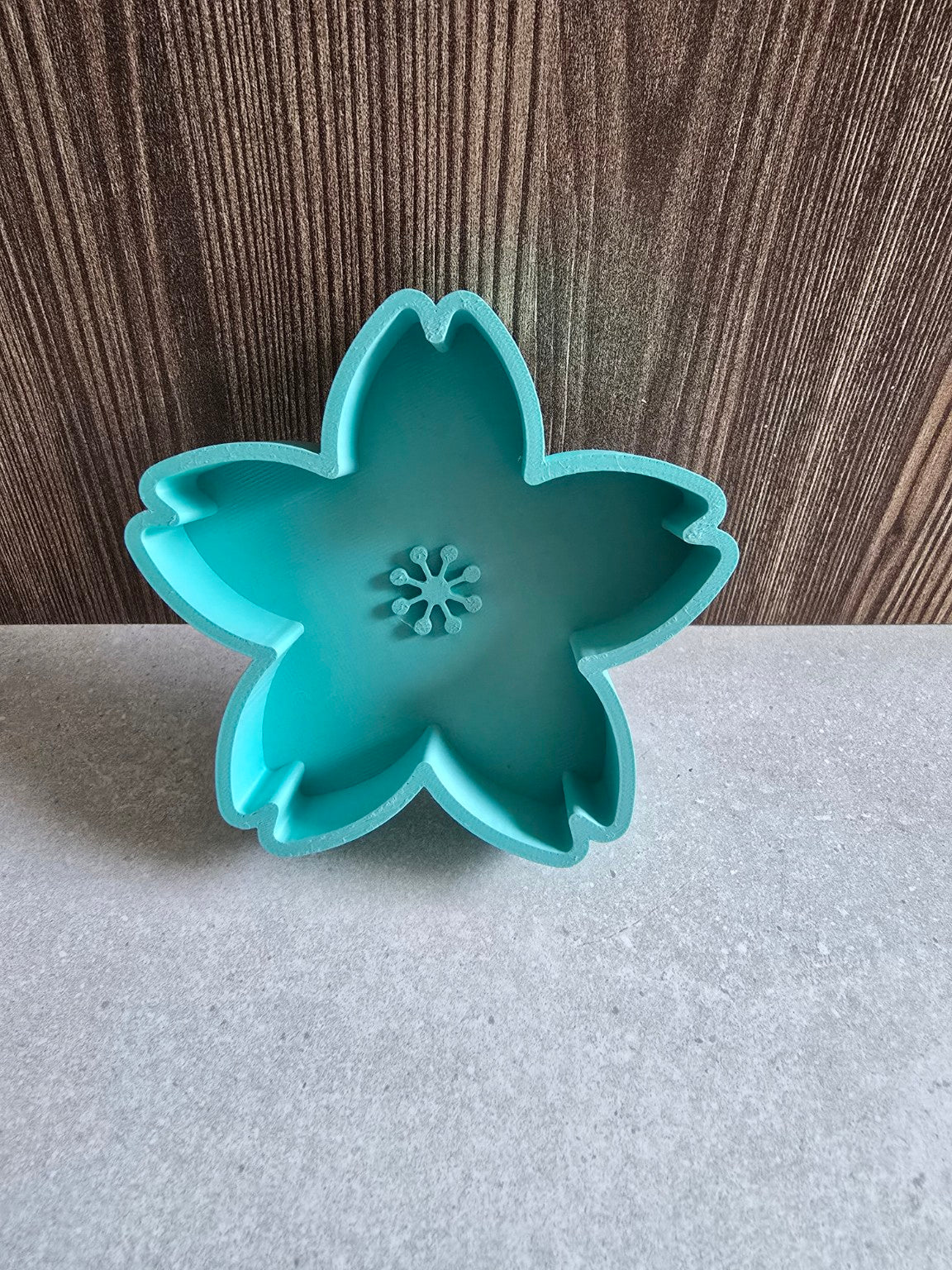Teal cherry blossom jewelry dish showing its petal-shaped compartments.