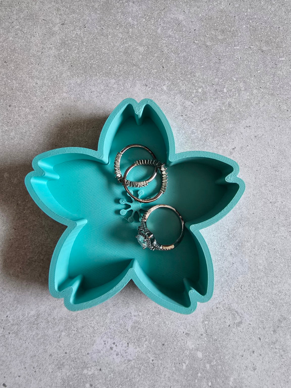 Teal cherry blossom trinket dish holding rings.