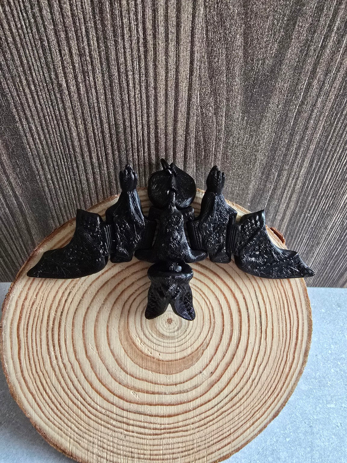 Black bat keychain on wooden slice