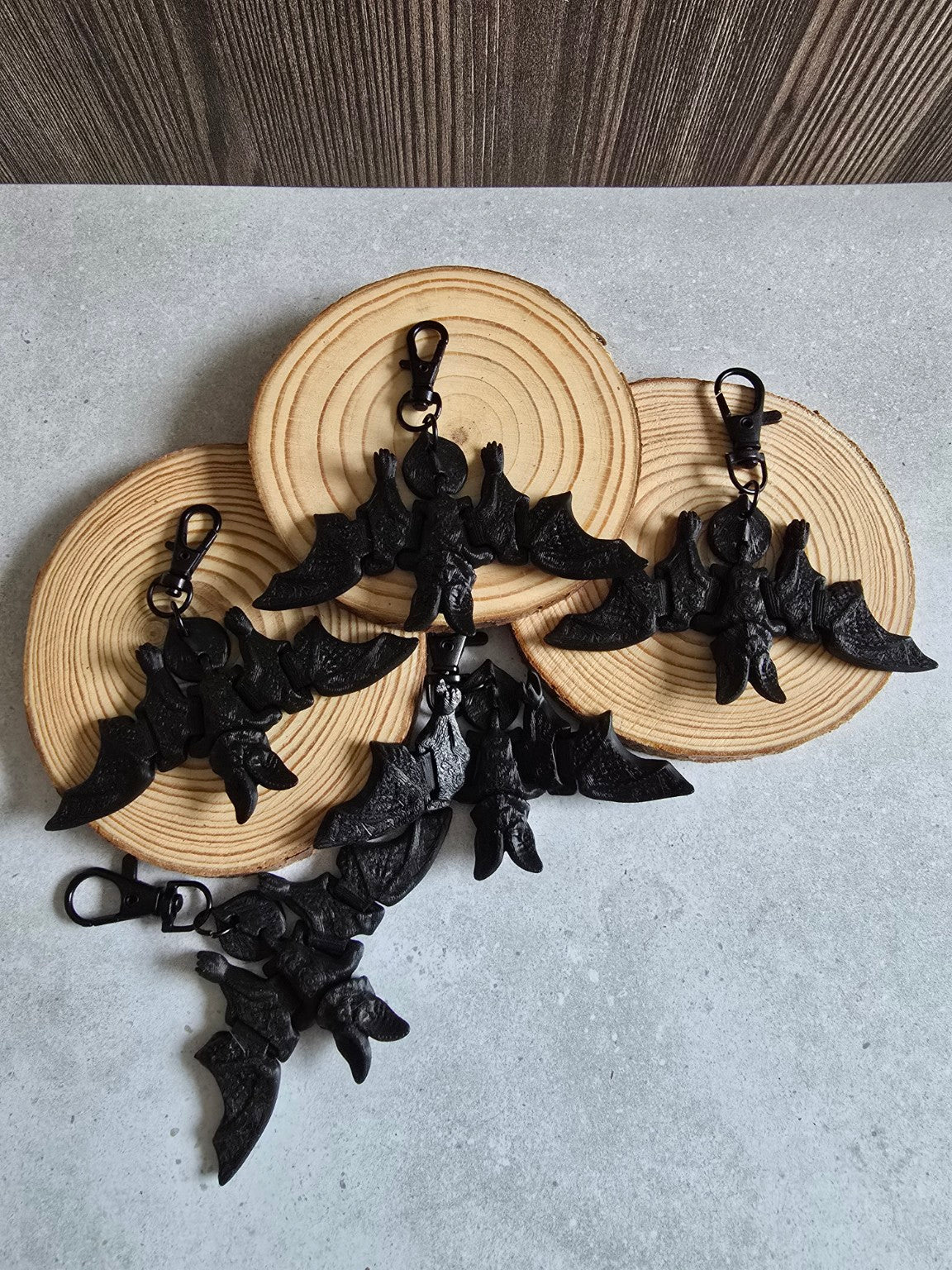 Four black articulated bat keychains