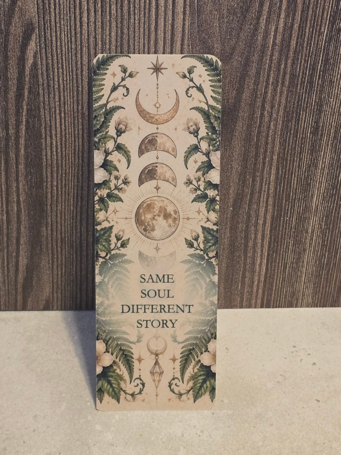Laminated bookmark with the words Same Soul Different Story in a vintage woodland and celestial design.